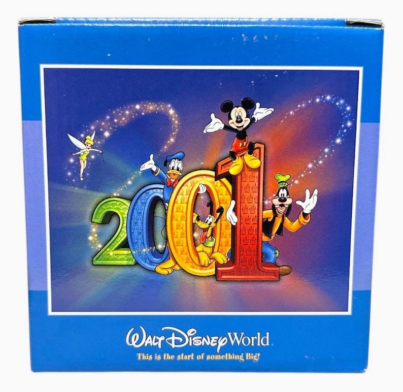 May include: A blue box featuring a colorful graphic of Disney characters, including Mickey Mouse, Donald Duck, and Goofy, celebrating "2001". The text "Walt Disney World" and "This is the start of something Big!" are also visible.