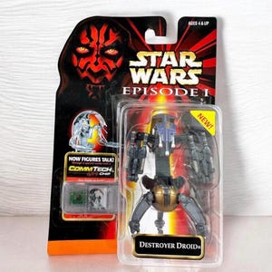 Pode incluir: Figura de ação Star Wars Episódio I Destroyer Droid na embalagem original. A embalagem apresenta Darth Maul e o texto "NOW FIGURES TALK!" e "COMMTECH CHIP". O brinquedo está em uma caixa de plástico transparente com um adesivo "NEW!".