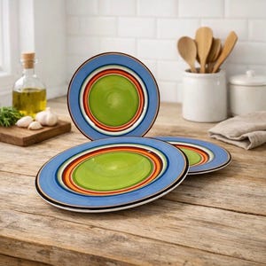 Puede incluir: Tres platos redondos de cerámica con un vibrante patrón de anillos concéntricos. El diseño consta de un centro verde lima brillante rodeado por bandas de color naranja, rojo y marrón oscuro, con un borde ancho azul claro y filo negro.