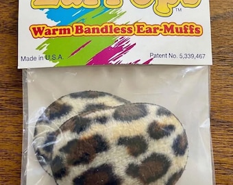 May include: EarPops brand bandless ear-muffs in a leopard print pattern. The packaging features the text EarPops, Warm Bandless Ear-Muffs, Made in U.S.A., and Patent No. 5,339,467. The ear-muffs are enclosed in a clear plastic bag.