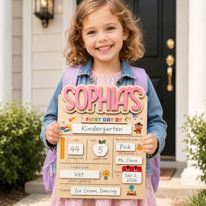 May include: A wooden first day of school sign featuring the name Sophia in pink letters. The board includes sections for grade, height of 44 inches, age of 5, favorite color pink, teacher Ms. Clara, career goal of Vet, date Sep 2, 2026, and interests.
