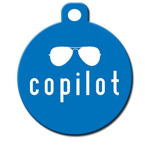 May include: A blue round tag with a white outline and a white pair of sunglasses and the word "copilot" in white letters.