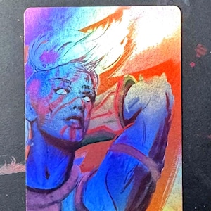 May include: A rectangular trading card featuring a stylized illustration of a figure with short, light-colored hair and blank white eyes. The artwork uses a vibrant color palette of blue, purple, and orange, with a metallic, holographic finish.