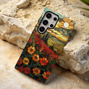 May include: A phone case with a stained glass design featuring a sunset over a field of flowers. The case has a camera cutout with a three-lens camera.