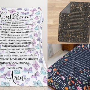 May include: Blanket with a butterfly pattern and personalized text. The text includes a name, a message about motherhood, and a Bible verse. The blanket is white with pastel butterflies.
