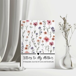 May include: A hardcover journal titled "Letters to My Mother" with a floral design. The cover features watercolor flowers in pink, purple, and orange on a white background. The journal includes the text "A Keepsake Journal of Love and Gratitude".