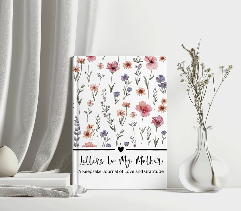 May include: A hardcover journal titled "Letters to My Mother" with a floral design. The cover features watercolor flowers in pink, purple, and orange on a white background. The journal includes the text "A Keepsake Journal of Love and Gratitude".