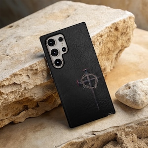 May include: Black phone case with a textured leather finish. The case features a silver cross with a crown of thorns design.