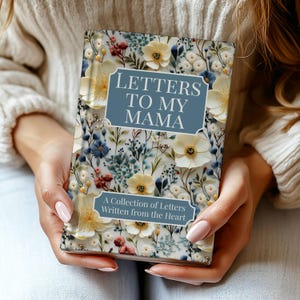 May include: A floral-covered journal titled "Letters to My Mama" is held in someone's hands. The cover features a blue banner with the title and a collection of letters. The journal is decorated with white, yellow, blue, and red flowers.