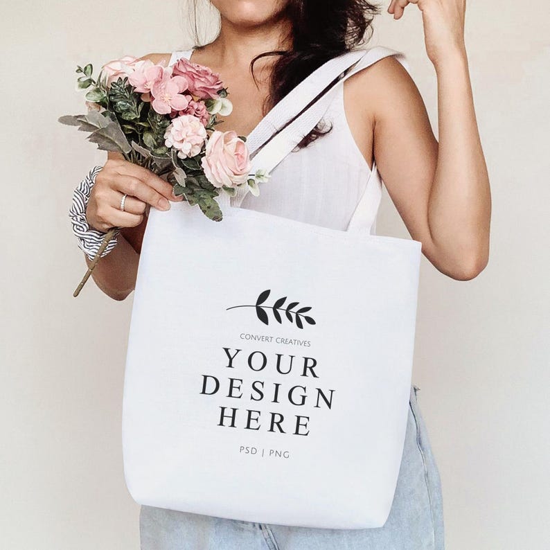 May include: White tote bag with black straps and a simple design. The bag has a black leaf design and the text "CONVERT CREATIVES YOUR DESIGN HERE PSD | PNG".