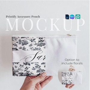 May include: A white canvas zippered pouch with a black floral print and the word "Sar" written in cursive. The pouch is being held in a hand. There is a smaller version of the pouch in the background with the same design.