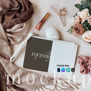 May include: A white and brown clutch bag with a zip closure. The bag features a black and white logo that reads "EQUESTRIAN ESTD CALIF". The text "Clutch Bag" is written in black on the white side of the bag. The bag is on a white surface with a brown scarf, a gold hair clip, a tube of lip gloss, a small jar of hand cream, and a pink hair scrunchie.