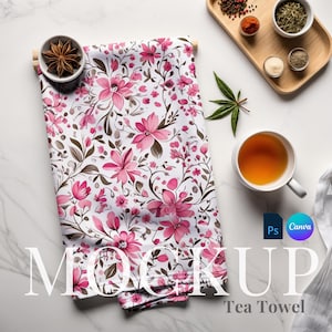 May include: A white tea towel with a pink floral pattern. The towel is folded and laid flat on a white marble surface. The text "MOCKUP Tea Towel" is printed on the surface below the towel.