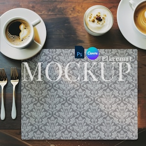 May include: A placemat mockup with a gray damask pattern, the word "MOCKUP" in large white letters, and the text "Placemat". Two cups of coffee, a small bowl of yogurt, and two forks are on a dark wooden table.
