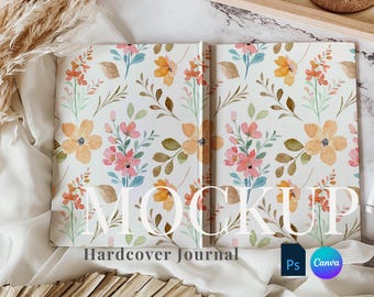 May include: A mockup of a hardcover journal with a floral design. The journal is open and the pages are blank. The journal is on a white surface with a piece of dried grass and a wooden box.