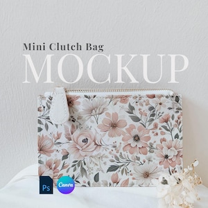 May include: A white clutch bag with a floral print. The bag has a zipper closure and a gold zipper pull. The bag is sitting on a white surface.  Mini Clutch Bag MOCKUP. Ps Canva