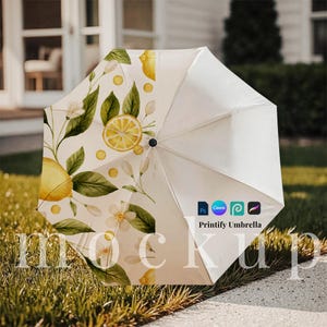 May include: A white umbrella with a lemon and floral design. The umbrella features a pattern of yellow lemons, green leaves, and white flowers. The text "Printify Umbrella" is visible on the umbrella.