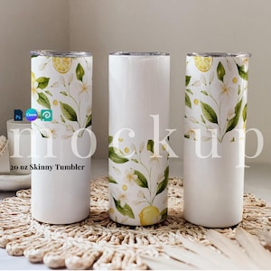 May include: Three 20 ounce skinny tumblers with a white background and a floral design featuring white flowers, green leaves, and yellow lemons. The tumblers are on a woven straw mat.