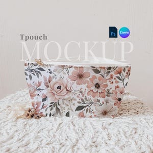Peut inclure: Une pochette zippée blanche avec un imprimé floral composé de fleurs roses et vertes. La pochette est posée sur une surface blanche et moelleuse. Le texte "Tpouch MOCKUP" est visible au-dessus de la pochette.