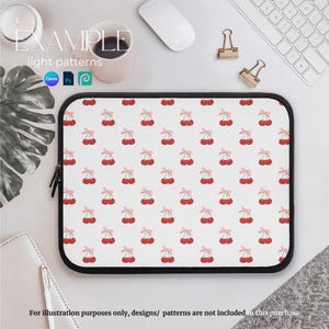 May include: A white laptop sleeve with a repeating pattern of red cherries with pink bows. The sleeve has a black zipper.