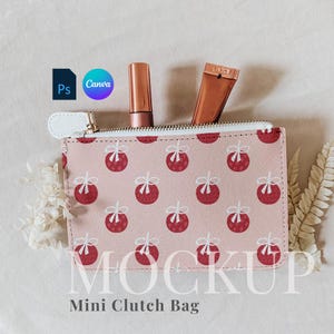 May include: A pink mini clutch bag with a white zipper and a red and white ornament pattern. The bag is open and has two tubes of makeup inside.