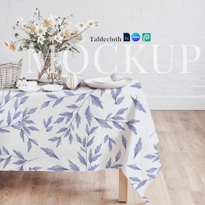 May include: White tablecloth with a blue floral pattern, set on a wooden table with a vase of flowers and a decorative egg. The text "Tablecloth" is visible in the top right corner of the image.
