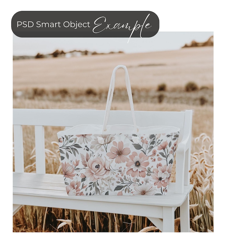 May include: A white tote bag with a floral print featuring pink, gray, and white flowers. The bag is sitting on a white bench.