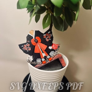 Puede incluir: Una artesanía de papel negro y rojo de una mujer con un kimono con el texto "kimono de felicidad".