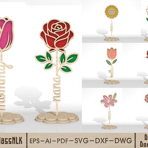 Puede incluir: Recortes de flores de madera en varios diseños, incluyendo un tulipán, una rosa, un girasol y una margarita. Cada flor tiene un nombre o término como "mamá" o "luna" recortado debajo. Las flores están sobre una base en forma de nube.