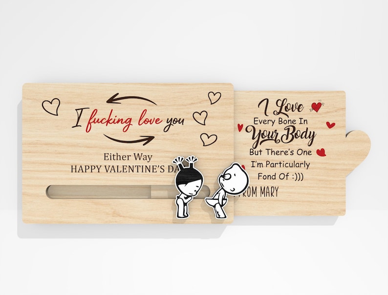 May include: A wooden Valentine's Day card with the text "I fucking love you" and "I love every bone in your body". The card features cartoon figures and heart illustrations. The card is light brown.