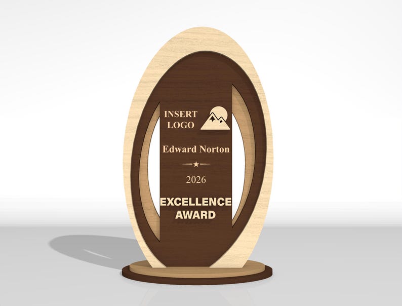 May include: An oval-shaped wooden award plaque featuring a light wood outer frame and a dark brown center panel. The center panel displays the text INSERT LOGO, a mountain icon, Edward Norton, 2026, and EXCELLENCE AWARD in light-colored lettering.
