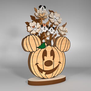 Könnte beinhalten: Ein hölzerner Kürbis mit einem Mickey-Maus-Gesicht und einem geschnitzten Lächeln. Der Kürbis ist mit Blumen und Mickey-Maus-Figuren verziert.