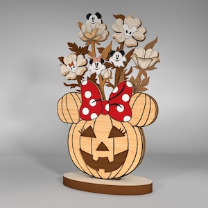May include: A wooden pumpkin with a carved jack-o'-lantern face, topped with a red and white polka dot bow and a bouquet of white flowers with cartoon mouse faces.