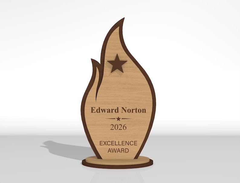 May include: A flame-shaped wooden award plaque featuring a dark brown border and a light wood grain center. It displays a dark brown star at the top and the text Edward Norton, 2026, and EXCELLENCE AWARD engraved in dark brown lettering on the front.