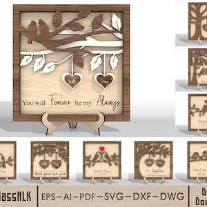 Puede incluir: Arte de pared de madera con un diseño enmarcado. El arte presenta una rama de árbol con pájaros, hojas y dos colgantes en forma de corazón. Se muestra el texto "You will Forever be my Always". También se muestran piezas de arte de madera más pequeñas adicionales.