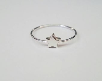 May include: A silver ring with a star-shaped design.