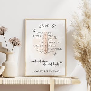 Peut inclure: Une carte d'anniversaire imprimable avec un fond rose clair et un cadre blanc. La carte pr&eacute;sente une grille de mots crois&eacute;s avec les mots "clever", "herzlich", "sexy", "ehrgeizig", "grossz&uuml;gig", "liebevoll" et "begabt". Le texte "Du bist..." et "Joyeux anniversaire !" est &eacute;galement inclus.