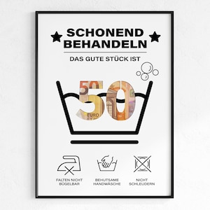 Op de afbeelding: Een ingelijste print met Duitse tekst en wassymbolen. De tekst luidt "SCHONEND BEHANDELN" en "DAS GUTE STÜCK IST" boven een afbeelding van een wasmachine met het nummer "50" erin, gemaakt van eurobiljetten. Hieronder staan wassymbolen.
