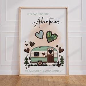 May include: A framed print featuring a teal and brown camper illustration with heart accents. The print includes the text "F&Uuml;R DAS N&Auml;CHSTE Abenteuer" and "HERZLICHEN GL&Uuml;CKWUNSCH". Two heart-shaped illustrations contain currency.