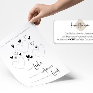 May include: A white card with black hearts and the text "Zur Hochzeit w&uuml;nschen wir euch von Alles Liebe, Dazu ganz viel Amore und einer gro&szlig;en Portion Love!"  The card also has the text "kunstraum. Die Geldscheine dienen nur zur besseren Veranschaulichung und sind NICHT auf der Datei vorhanden!"