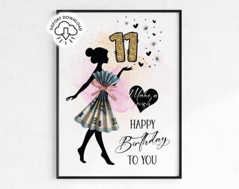May include: A framed print with a black silhouette of a woman holding up the number 11 in gold glitter. The woman's dress is made of folded money, and the words "Make a wish" and "Happy Birthday to You" are written on the print.