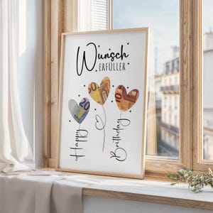 May include: A framed print featuring three heart-shaped balloons made of Euro banknotes. The balloons are connected by stems and the words "Happy Birthday" are written vertically. The German words "Wunsch Erf&uuml;ller" are at the top.