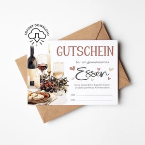以下が含まれることがあります： ブルゴーニュ色の「GUTSCHEIN」という文字が入ったギフト券で、その下に「für ein gemeinsames Essen」という文字が入っています。画像にはワインボトル、グラス、ブドウ、ろうそくが写っています。証明書は茶色の封筒に入っています。