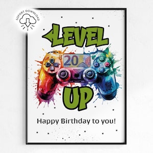 May include: A framed print featuring a colorful watercolor-style video game controller. The words "LEVEL UP" and "Happy Birthday to you!" are displayed in bold text. The controller is a mix of red, orange, blue, and green.