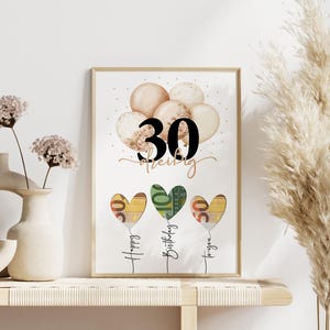May include: A framed print with a birthday theme. The print features the number "30" above a series of heart-shaped balloons. The balloons are in shades of beige and gold. Below the balloons are three heart-shaped balloons made of currency, with the words "Happy Birthday to you".