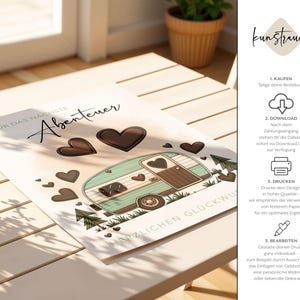 May include: A printed card featuring a teal and brown camper illustration with heart accents. The card includes the text "F&uuml;r das n&auml;chste Abenteuer" and "Herzlichen Gl&uuml;ckwunsch". The card is on a light-colored wooden surface.