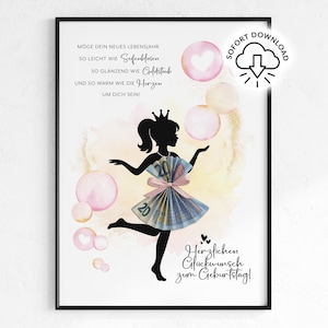 May include: A framed print featuring a black silhouette of a woman wearing a crown and a dress made of money. The artwork includes pink and gold accents, with text in German wishing a happy birthday. Bubbles and hearts are also included in the design.