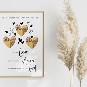 May include: A white card with a gold frame, featuring a heart-shaped design with money inside. The card has the text "Zur Hochzeit w&uuml;nschen wir euch von Alles Liebe, Amore und einer gro&szlig;en Portion Love!"