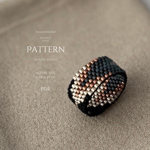 Peut inclure: Un modèle de bague perlée en point de peyote. La bague est noire, argentée et cuivrée, avec une taille réelle de 6,55 cm sur 0,94 cm. Le texte sur l'image indique "PATTERN" et "BEADED RING".