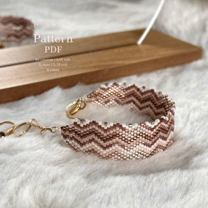 May include: A beaded peyote bracelet with a zigzag pattern in shades of white, brown, and gold. The bracelet is 4.46 inches long and features 84 columns and 11 rows. The image also includes text that says "Pattern PDF".